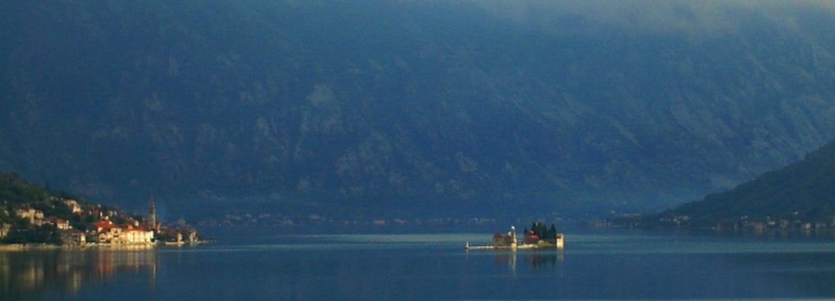 Panoramski pogled na Bokokotorski zaliv i ostrvo u Morinju, Crna Gora: slikovit pejzaž sa planinskim krajolikom i morem.