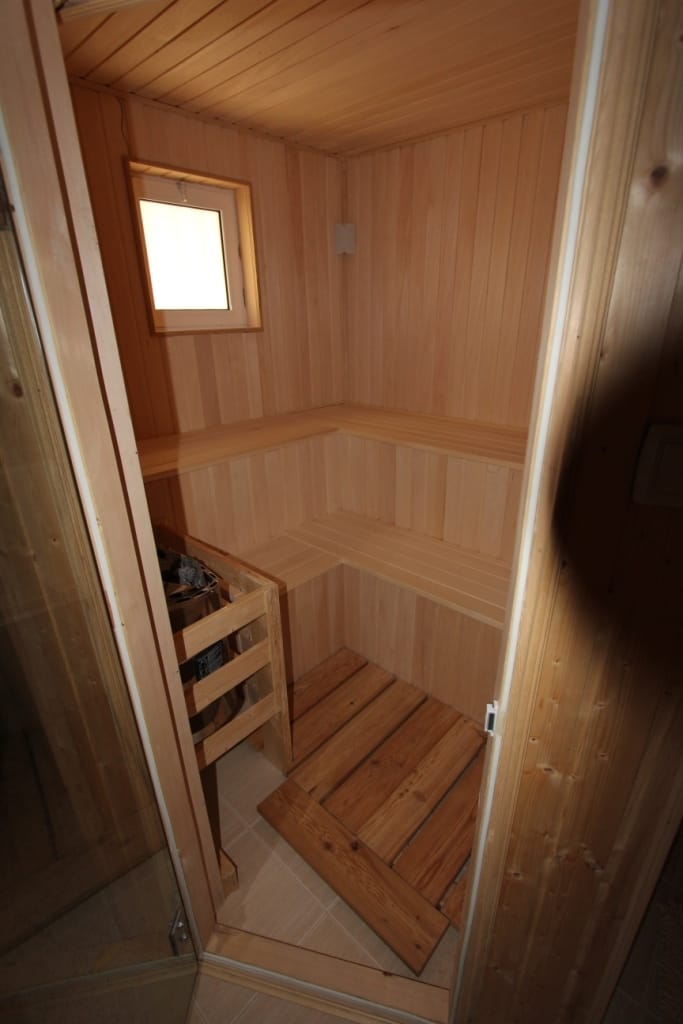 Kućna sauna sa oblogom od svetlog drveta u kući na Barskoj rivijeri, Crna Gora: police i peć za paru.