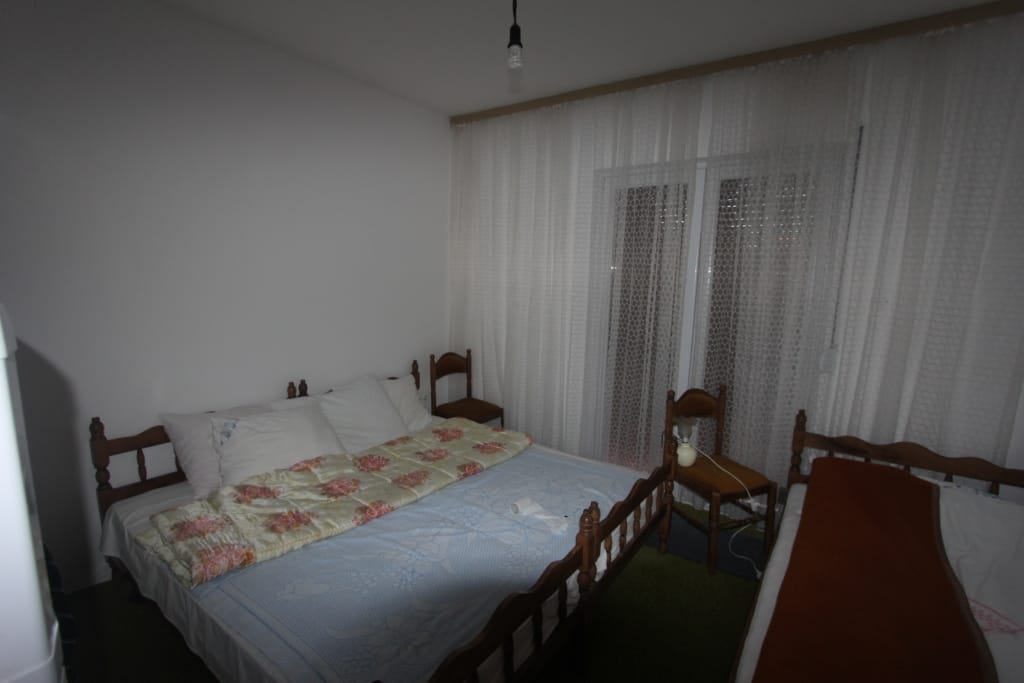 Chambre avec lits en bois et accès au balcon dans une maison, ville de Radovici, Monténégro.