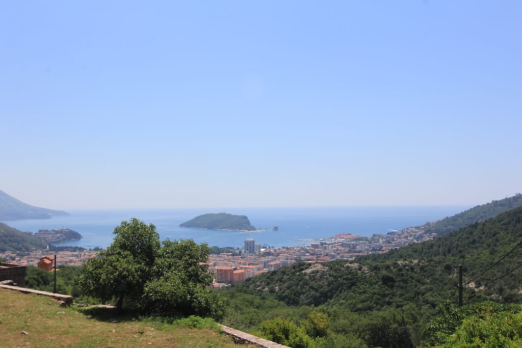 Panoramski pogled na more, ostrvo Svetog Nikole i grad Budvu, Crna Gora, sa teritorije privatne kuće u planinama.
