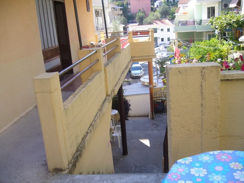 Otvorena terasa mini-hotela u Rafailovićima, Crna Gora: pogled s balkona na unutrašnje dvorište i parking kod kuće.