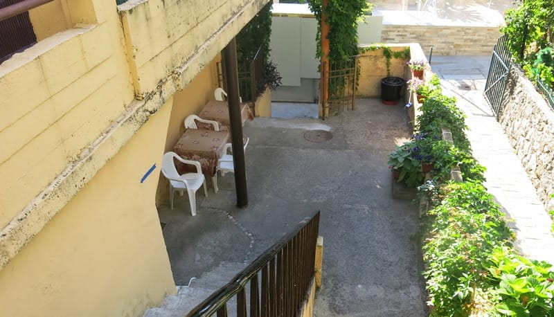 Ugodna terasa sa trpezarijskim delom i baštom kod mini-hotela u Rafailovićima, Crna Gora: pogled na unutrašnje dvorište i stepenište.
