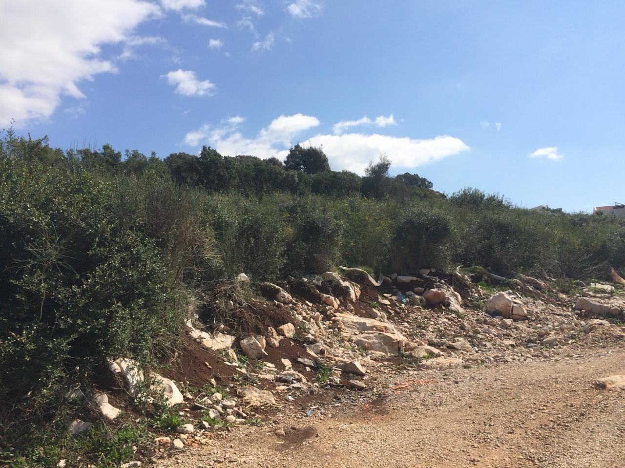 Građevinsko zemljište u Dobrim Vodama, Crna Gora: brdovit teren sa kamenjem i zelenim žbunjem.
