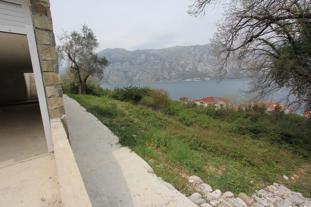 Pogled na Bokokotorski zaliv i planine sa terase kuće u Prčanju, Crna Gora: kamena obloga i panoramski morski pejzaž.