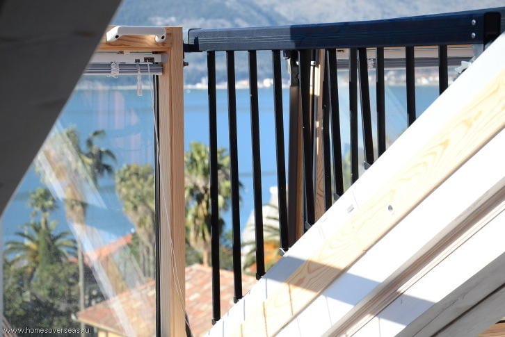 Blick vom Balkon der Dachgeschosswohnung in Herceg Novi, Montenegro: Holzgeländer und Panoramablick auf das Meer und Palmen.