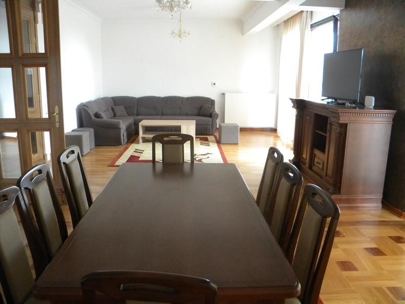 Przestronny salon z jadalnią i kącikiem wypoczynkowym w willi w Herceg Novi, Czarnogóra: drewniane meble i parkiet.