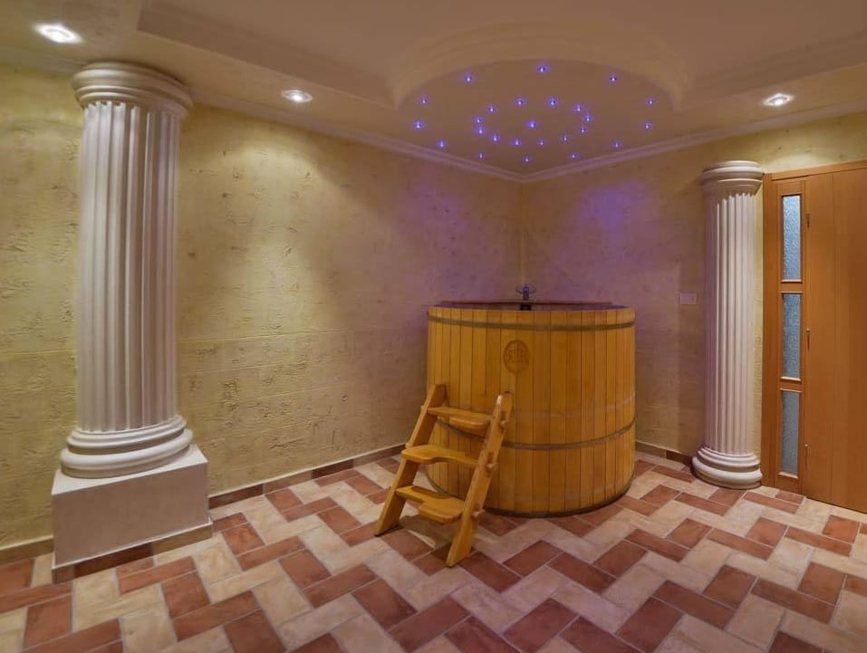 Strefa SPA z drewnianą balią i kolumnami w willi w Herceg Novi, Czarnogóra. Wykończenie płytkami i dekoracyjne oświetlenie.