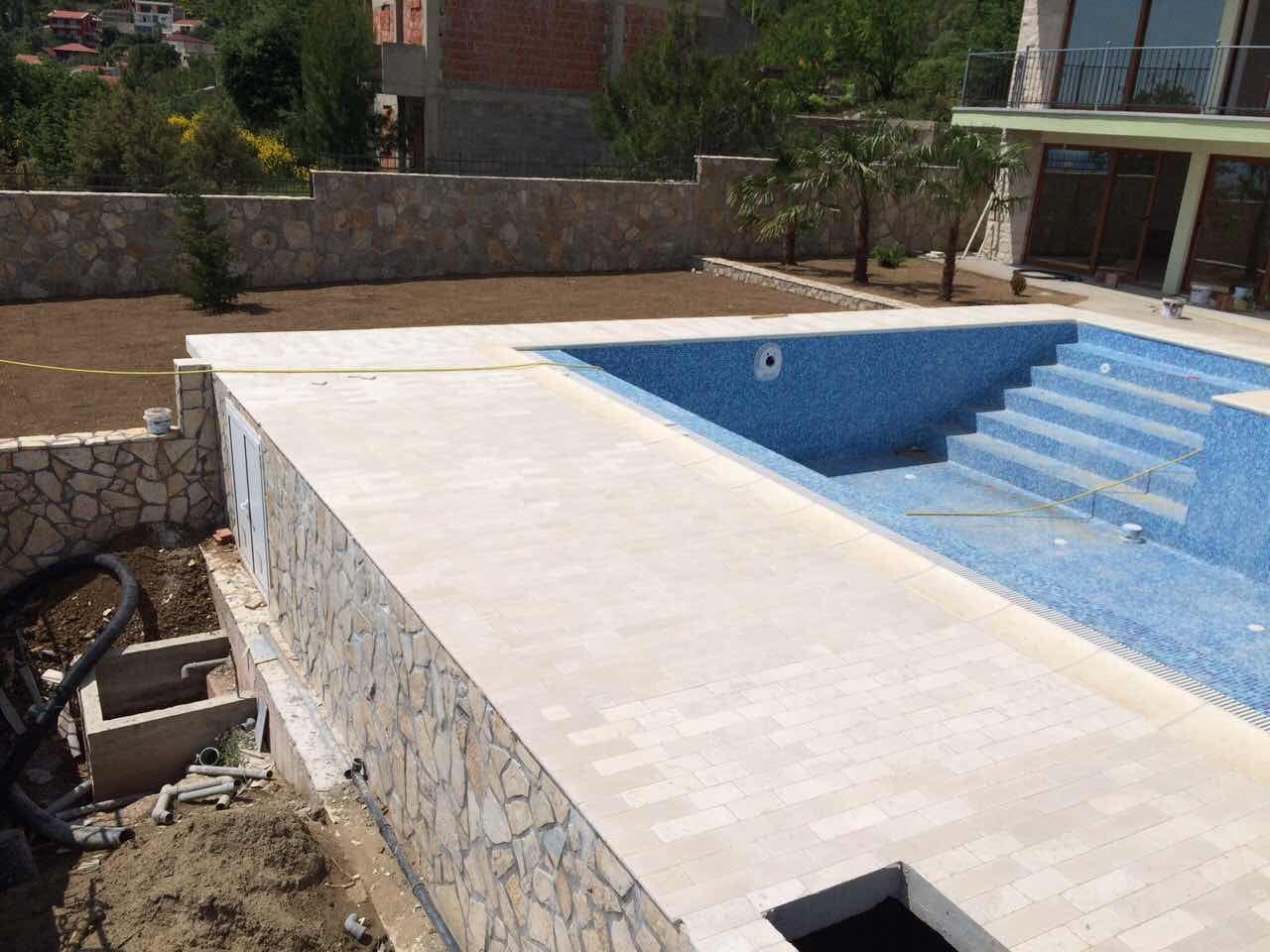 An under-construction pool with mosaic finish and a stone terrace at a villa in Shushan, Montenegro.