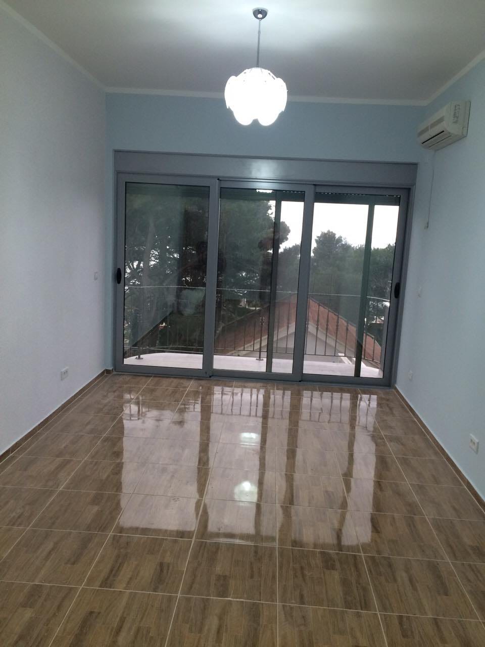 Svetla dnevna soba sa panoramskim prozorom i izlazom na balkon u kući, Šušanj, Crna Gora. Pločice na podu, klima uređaj.