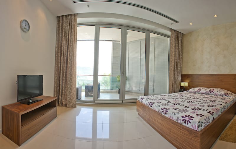 Modernes Schlafzimmer mit Doppelbett und Zugang zur Terrasse in einer Wohnung, Budva, Montenegro.