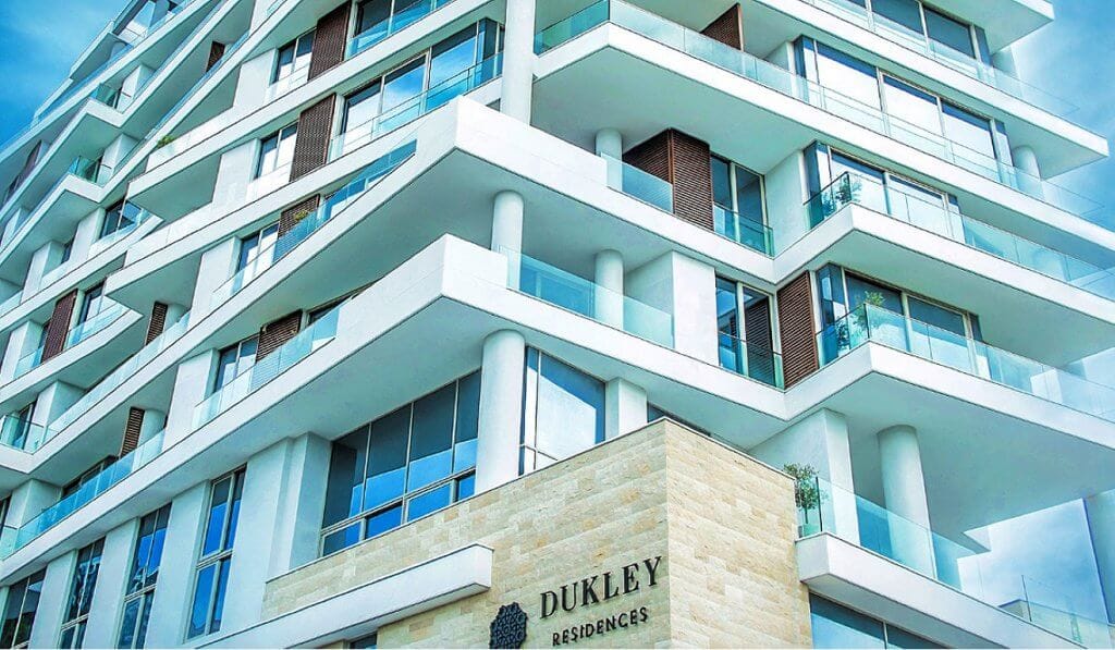 Savremeni stambeni kompleks Dukley Residences sa panoramskim balkonima i oblogom od kamena u Budvi, Crna Gora.