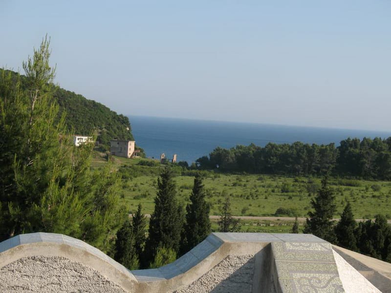 Panoramski pogled na more i zelene brežuljke sa terase kuće u Sutomoru, Crna Gora. Slikovit pejzaž sa četinarima.