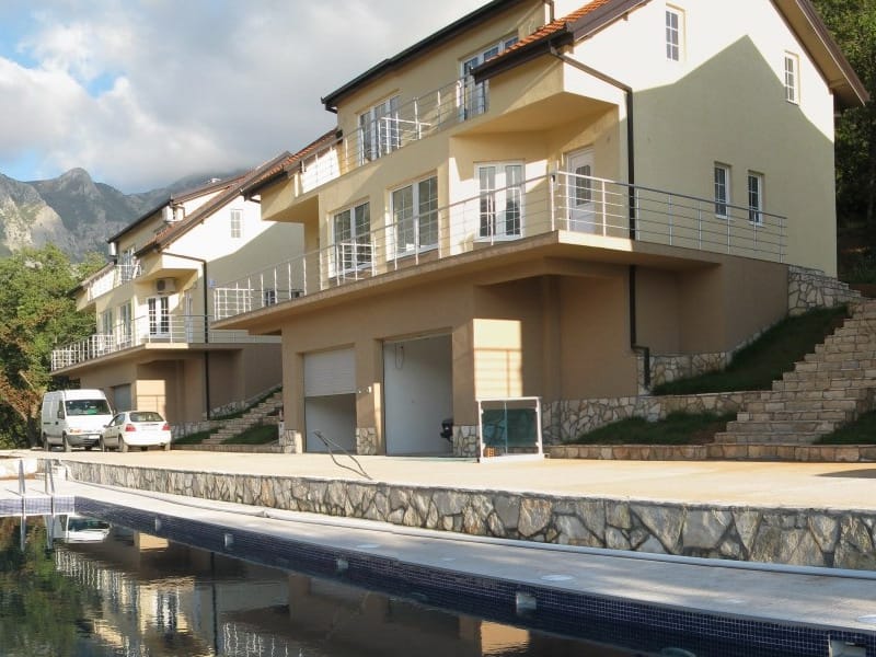 Modern villas with garages and a pool in Bar, Montenegro: view of the residential complex with terraces and mountains.