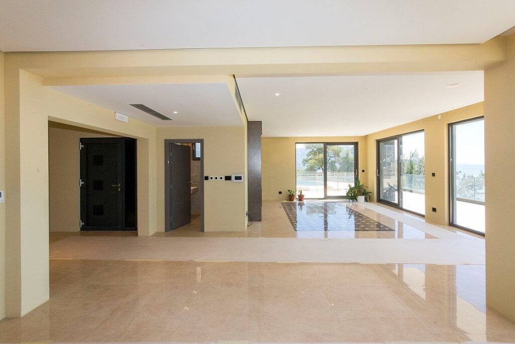 Spacious living room with panoramic windows and sea view in a modern villa, Budva, Montenegro.