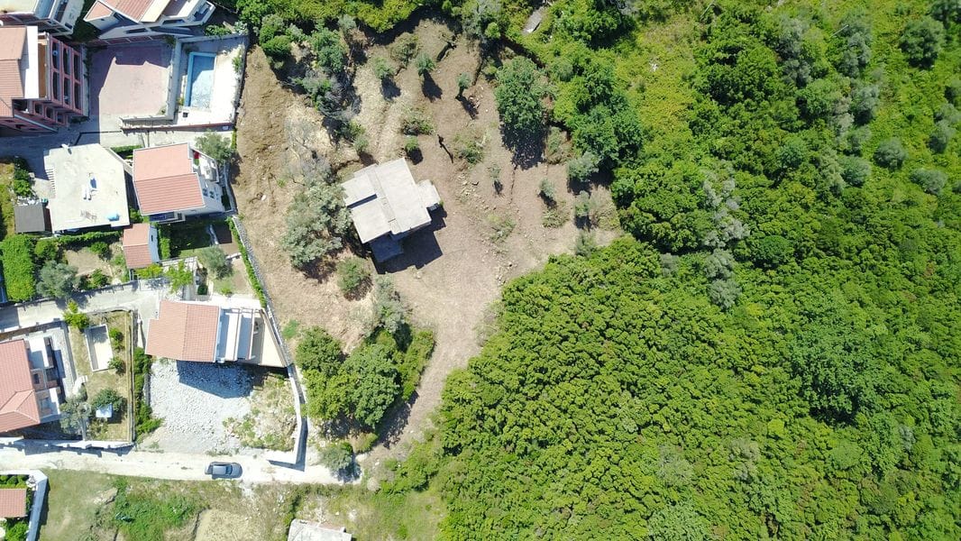 Karadağ, Bečići’de inşaat için arsa: ev ve yeşil alanla birlikte arazinin üstten görünümü.