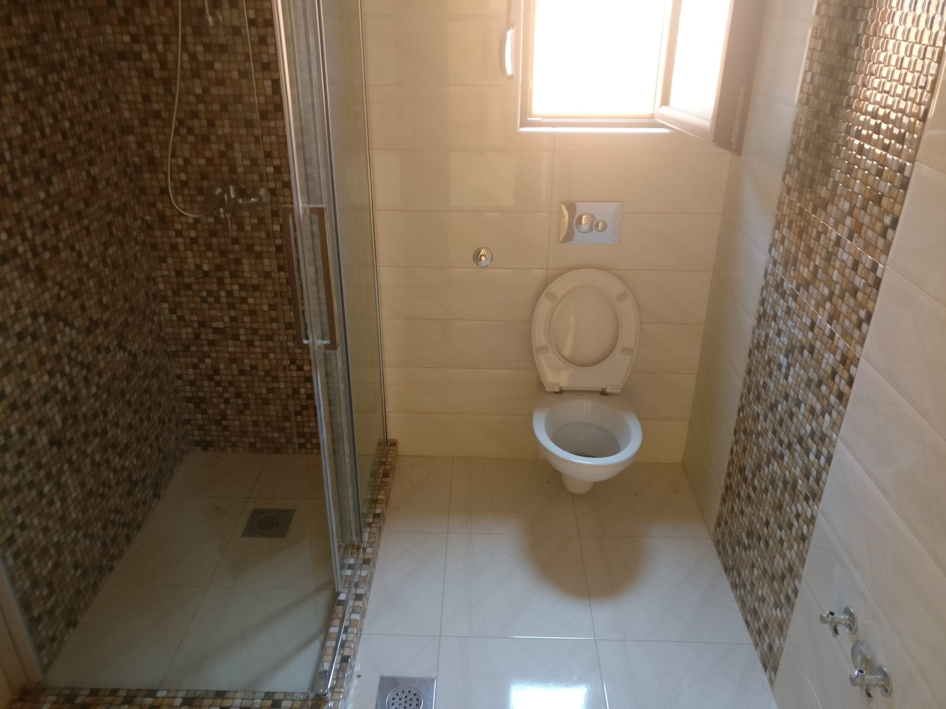 Savremeno kupatilo sa tuš kabinom i visećom WC šoljom u kući, Šušanj, Crna Gora.