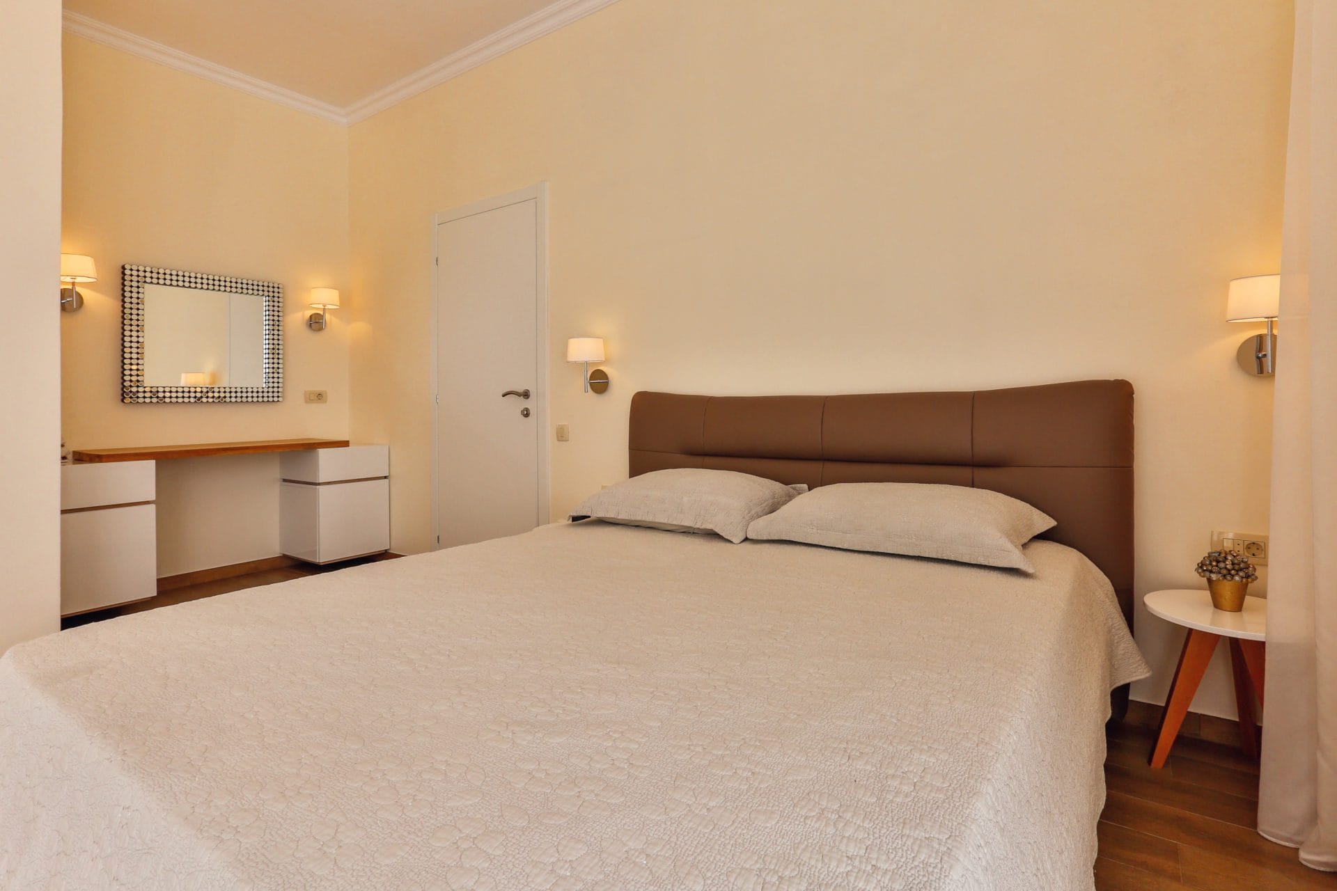 Cozy bedroom with a double bed and a dressing table in a villa in Tivat, Montenegro. Modern interior.
