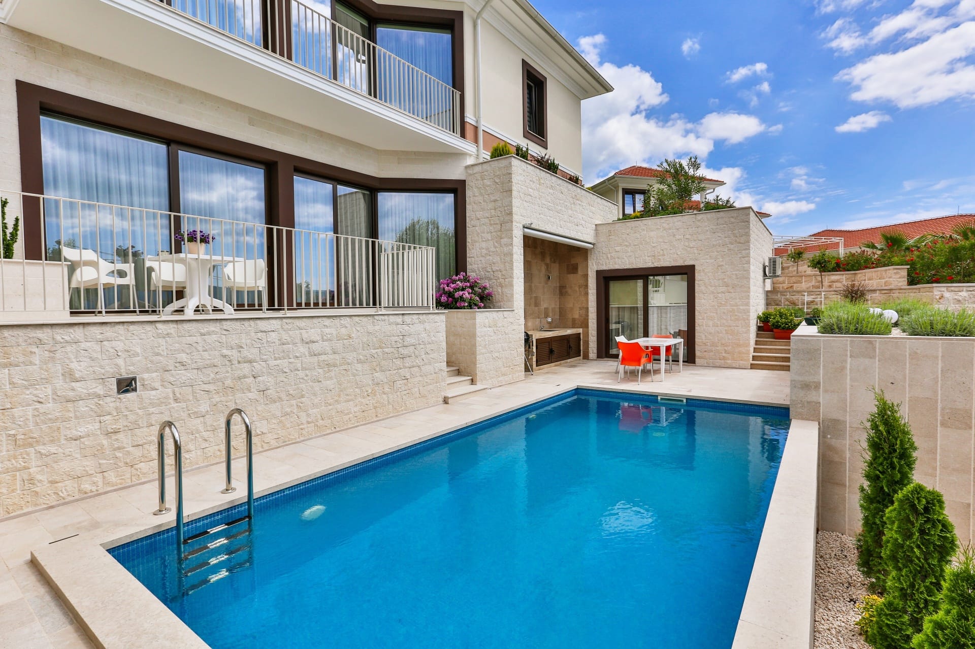 Modern villa with a pool, terrace, and stone finishes in Tivat, Montenegro. Exterior view of a private house.