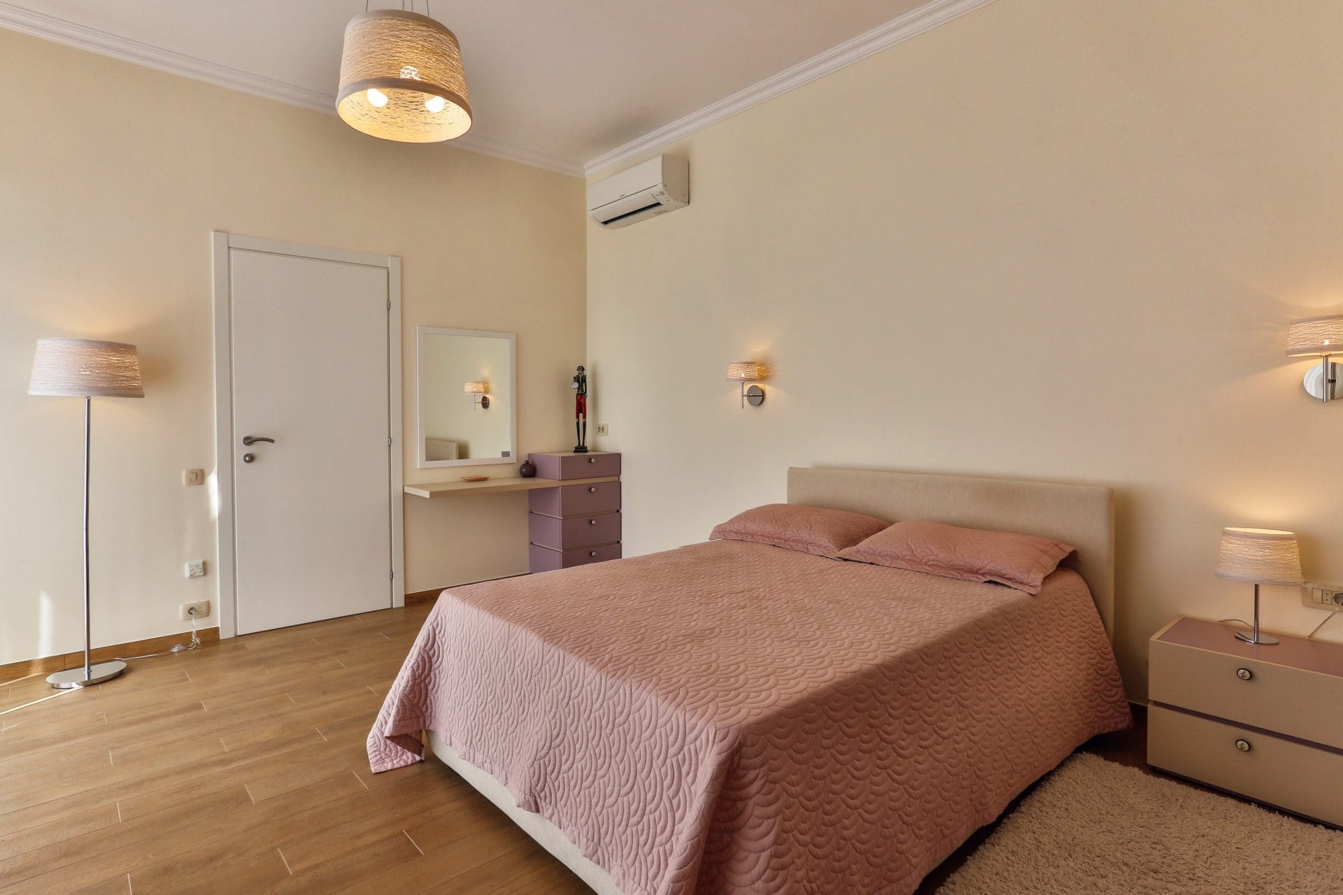 Cozy bedroom with a double bed and a dressing table in a villa in Tivat, Montenegro. Bright interior.