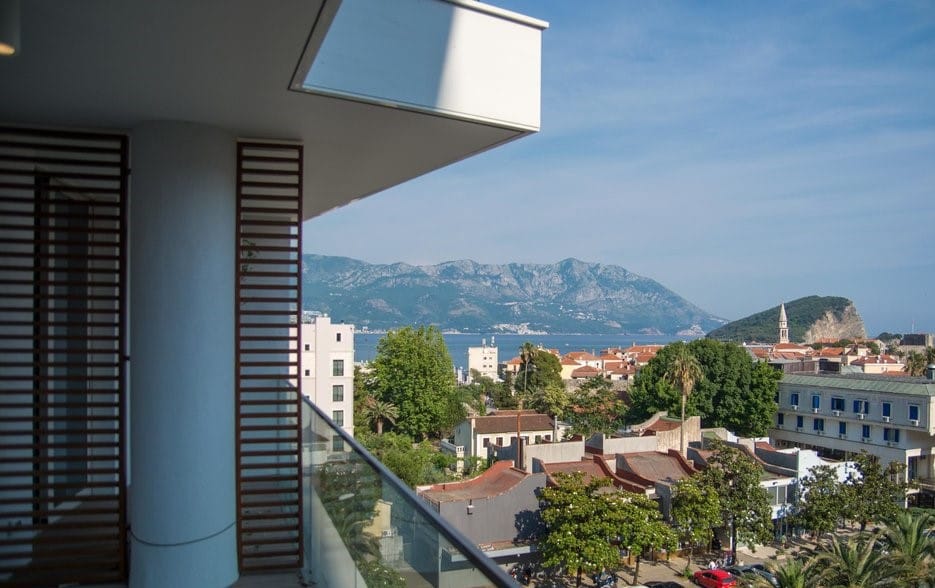 Pogled sa balkona modernog stana u Budvi, Crna Gora: panorama grada, planina i Jadranskog mora.