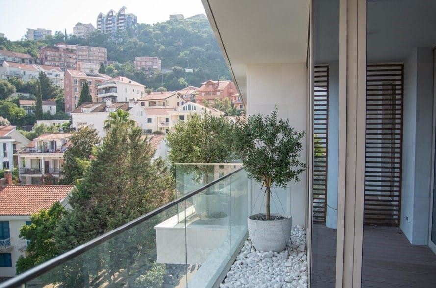 Moderan balkon sa maslinama i panoramskim pogledom na grad Budvu, Crna Gora.