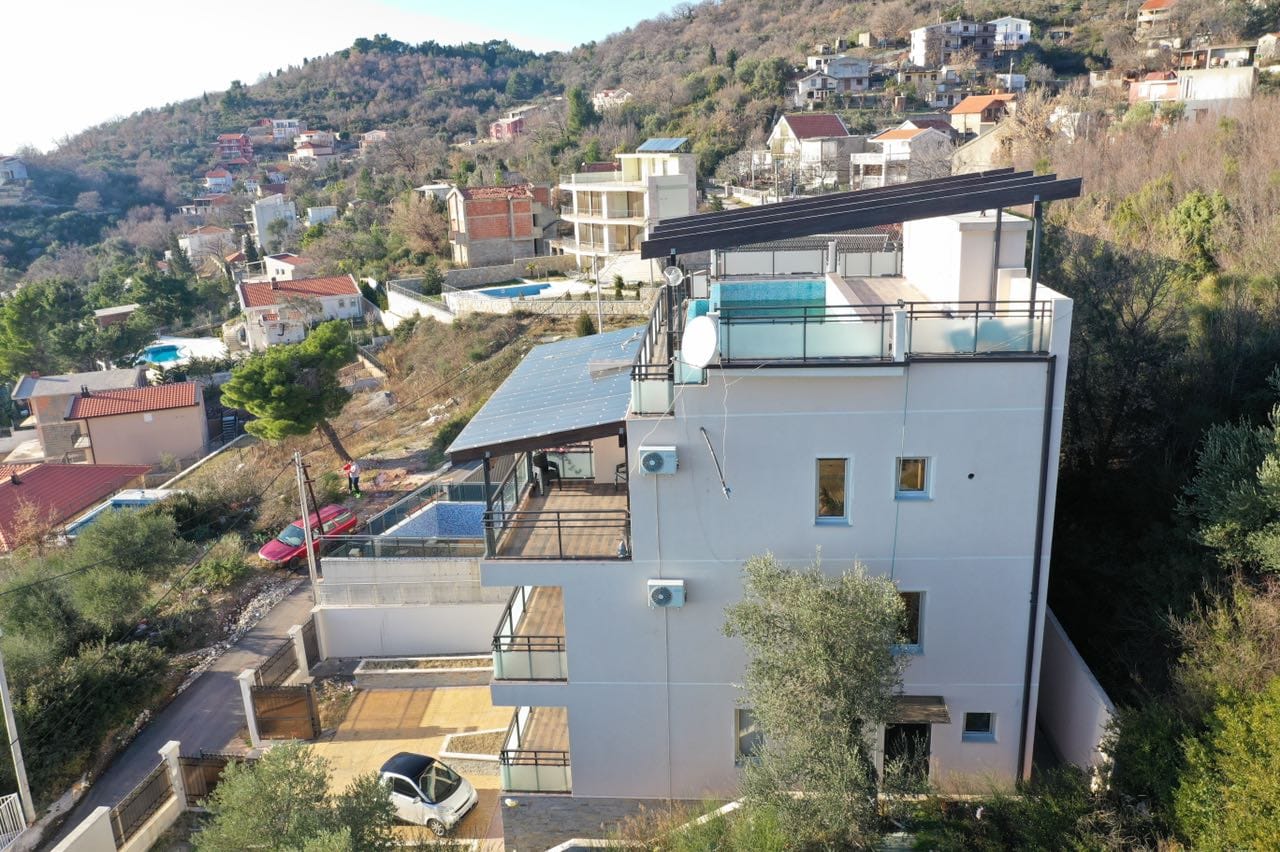 Savremena vila u Šušnju, Crna Gora: kuća sa terasama, bazenom na krovu i pogledom na planine i more.
