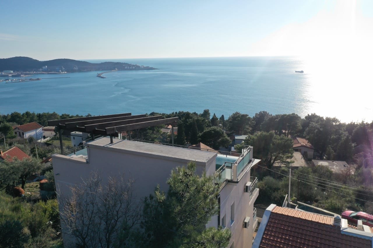 Pogled na kuću sa bazenom na krovu i panoramskim pogledom na more u Šušnju, Crna Gora. Savremena arhitektura i terasa.