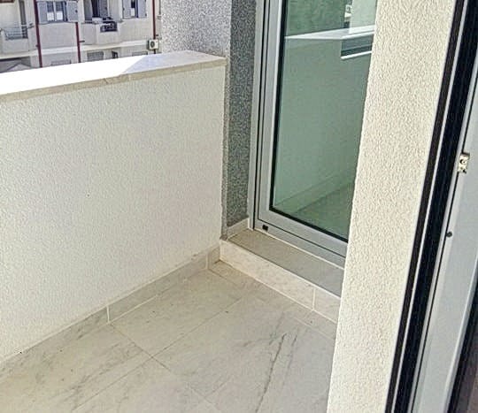 Svetao balkon sa panoramskim zastakljenjem u stambenom kompleksu, Budva, Crna Gora: savremena završna obrada i pločice.