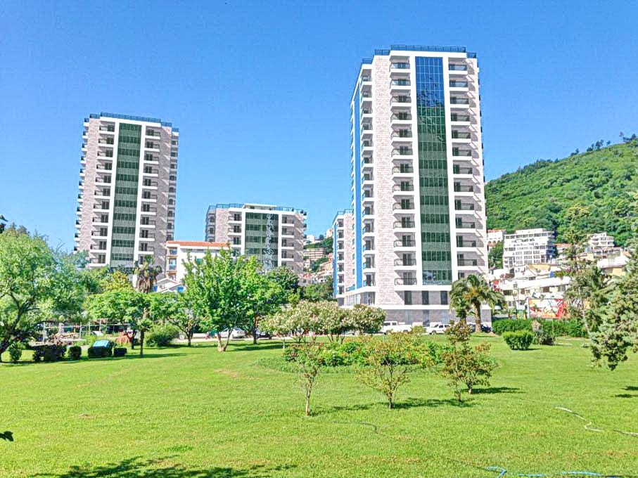 Savremeni stambeni kompleksi sa panoramskim prozorima i zelenim prostorom u Budvi, Crna Gora, pogled spolja.