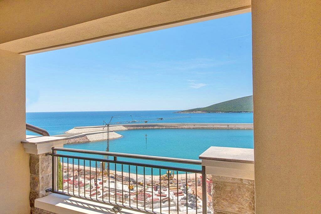 Pogled sa balkona stana u Luštici, Crna Gora: panorama Jadranskog mora i marine u izgradnji sa pristaništem.