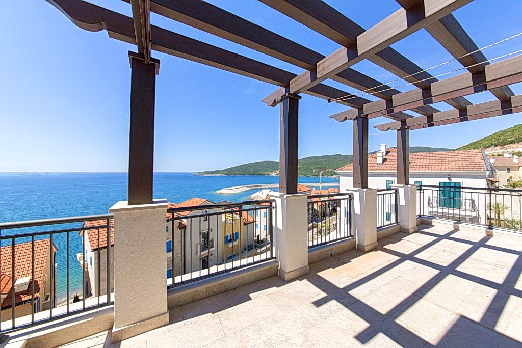 Prostrana terasa s pergolom i panoramskim pogledom na more u Luštici, Crna Gora. Stan s balkonom uz obalu.