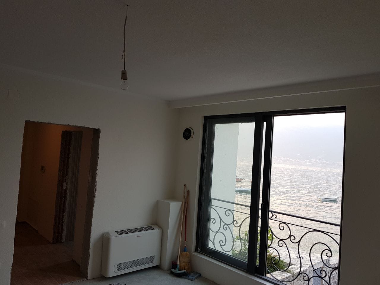 Dnevna soba sa panoramskim pogledom na more i balkonom u vili u izgradnji u Krašićima, Crna Gora.