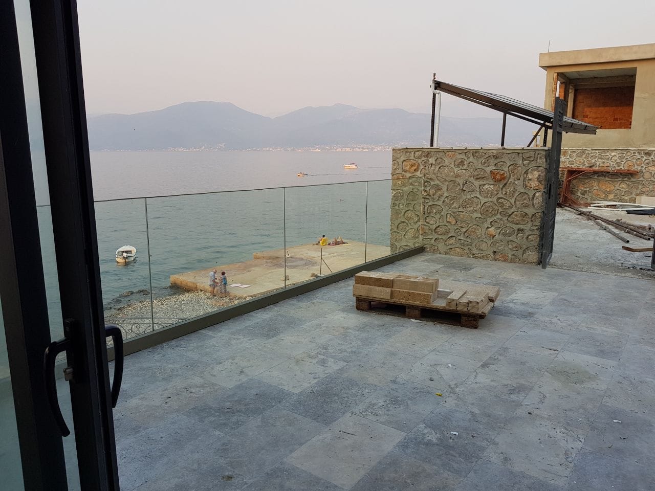 Terasa vile u Krašićima, Crna Gora: kamena obloga, staklena ograda i panoramski pogled na more i planine.