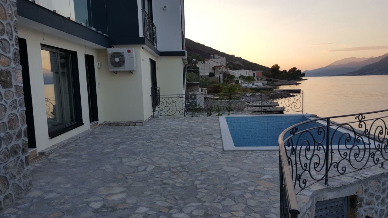 Vila u Krašićima, Crna Gora: terasa sa bazenom, kamena obloga fasade i panoramski pogled na more i planine.