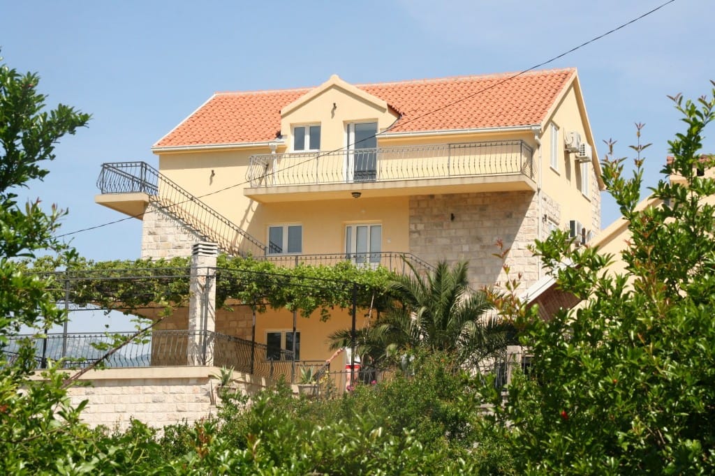 Trospratna vila u Dobroti, Crna Gora: kamena obloga, terasa sa vinogradom i balkon sa kovanim ogradama.