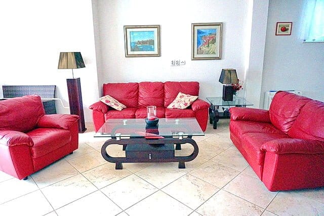 Living room with red leather furniture and a glass table in an apartment, Stoliv, Montenegro.