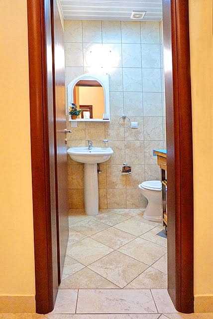 Bathroom with white sanitary ware and beige tiles in an apartment for sale in Stoliv, Montenegro.