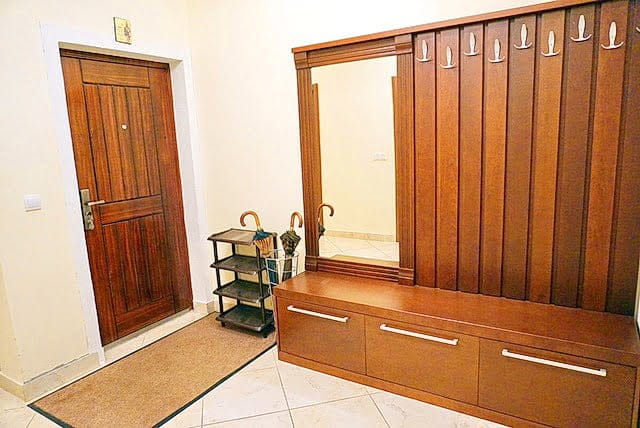 Hallway in an apartment in Stoliv, Montenegro: wooden furniture, built-in mirror, coat hooks, and a shoe rack.