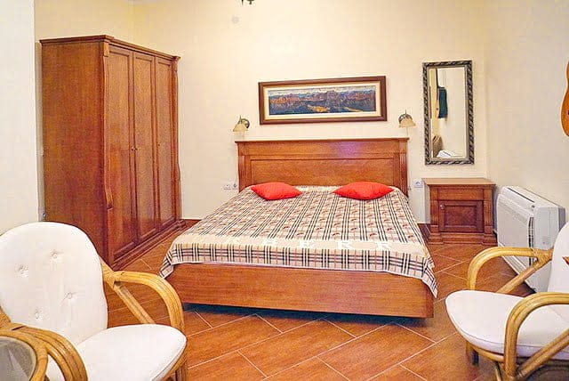 Cozy bedroom with a double bed and wooden furniture in an apartment for sale in Stoliv, Montenegro.