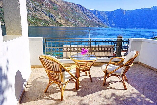 Balcony with rattan furniture and panoramic view of the Bay of Kotor, Stoliv, Montenegro.