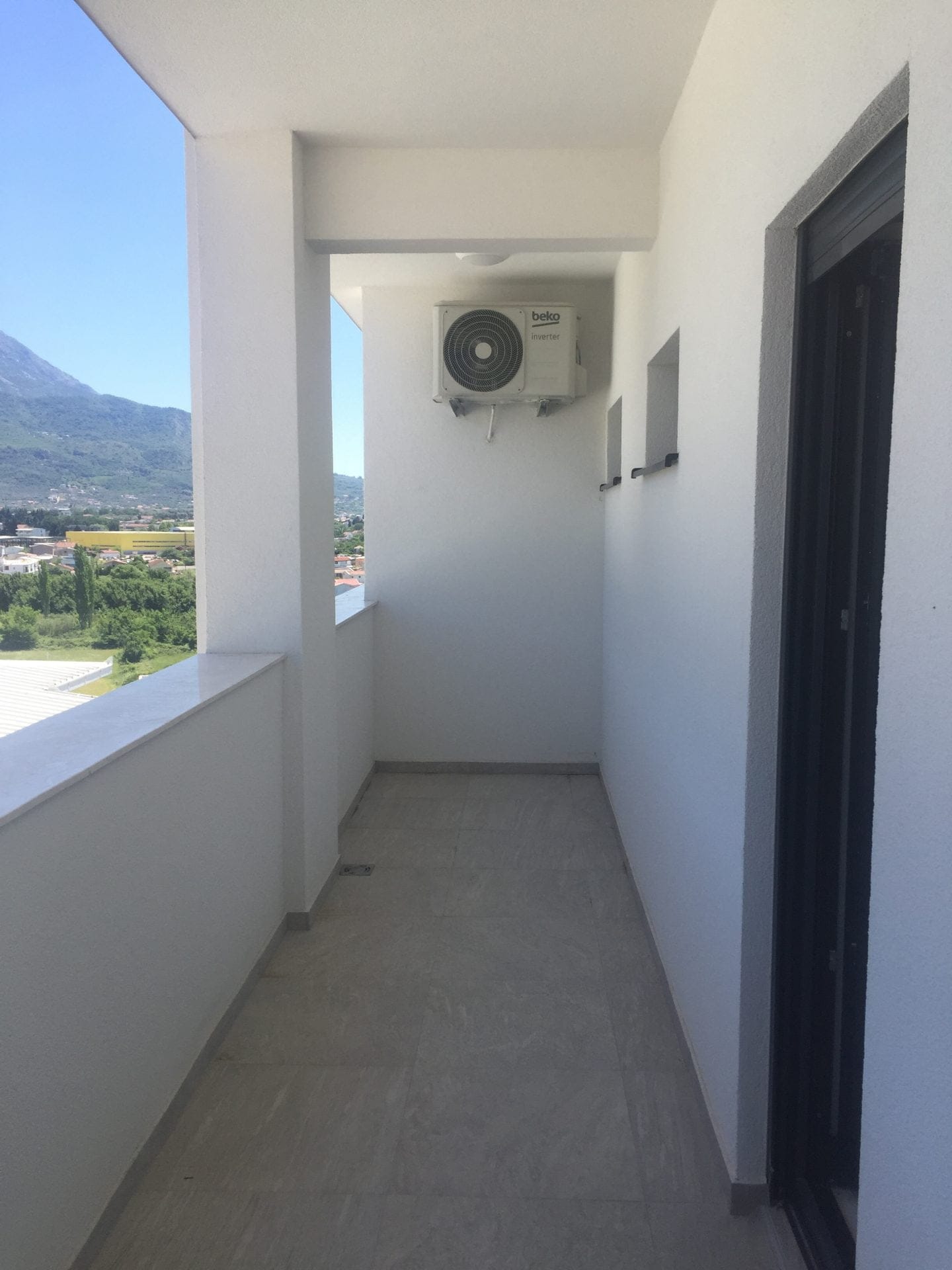 Heller Balkon mit Klimaanlage und Blick auf die Berge in einer Wohnung, Stadt Bar, Montenegro.