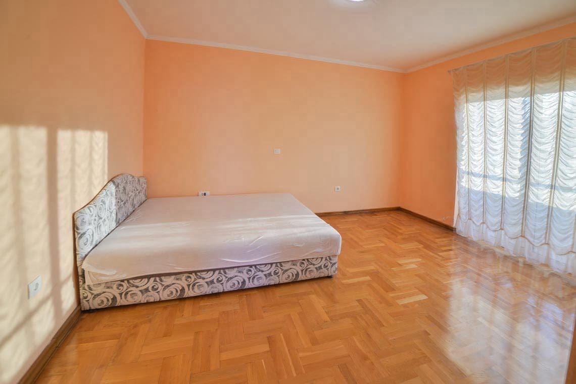 Svetla spavaća soba sa bračnim krevetom, parketom i panoramskim prozorom u stanu, Uteha, Crna Gora.