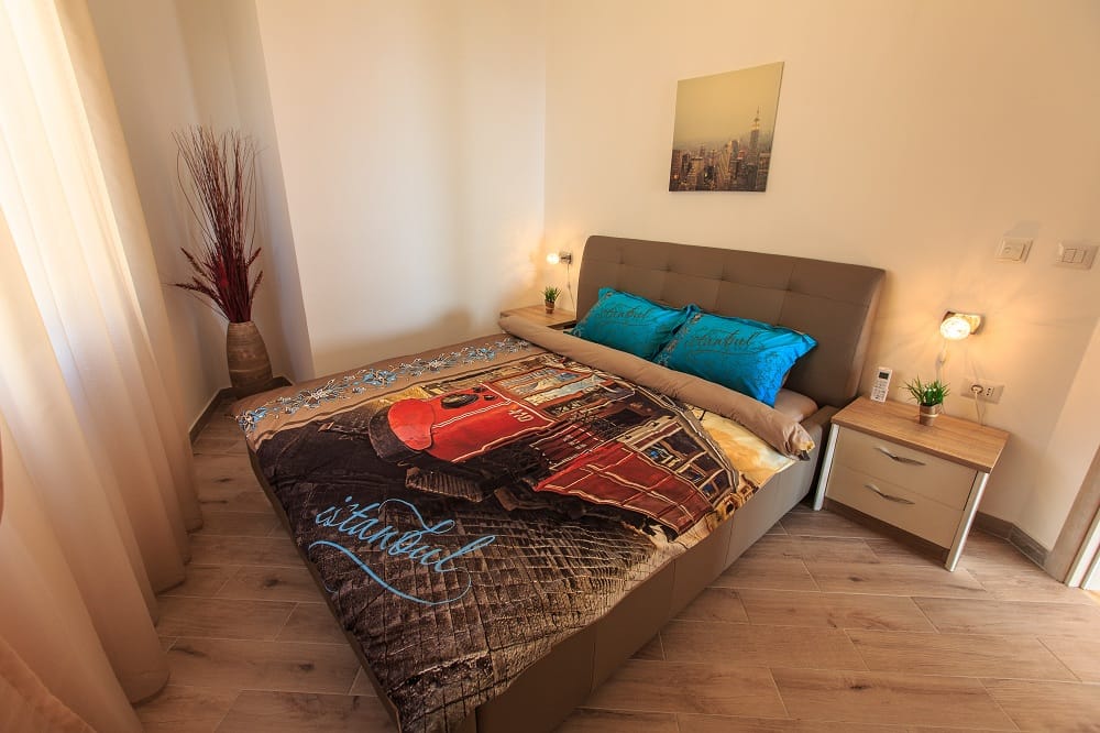 Gemütliches Schlafzimmer mit Doppelbett in der Wohnanlage Dobri Vody, Montenegro: moderne Ausstattung, helles Interieur und Dekor.