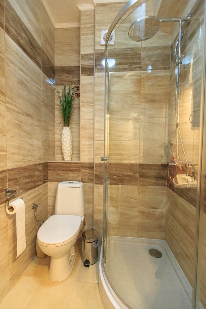 Modernes Badezimmer mit Duschkabine und beigen Fliesen in einer Wohnanlage, Dobre Vode, Montenegro.