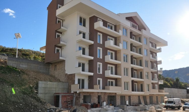 Savremena višespratnica sa balkonima u gradu Dobrota, Crna Gora, pogled na fasadu objekta u izgradnji