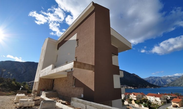 Savremena stambena kuća u Dobroti, Crna Gora, sa pogledom na Bokokotorski zaliv i planine, fasada obložena kamenom.