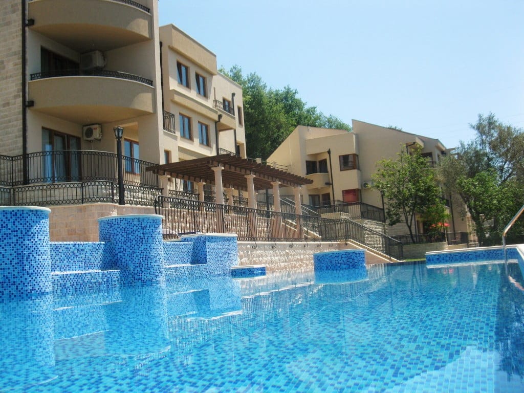 Savremeni stambeni kompleks sa bazenom i terasom u Herceg Novom, Crna Gora: pogled na apartmane i zonu za odmor.