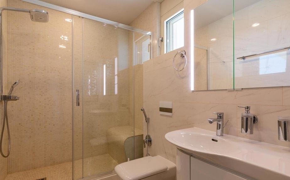 Becici, Karadağ’daki villada duş kabinli ve açık renkli kaplamalı modern banyo.