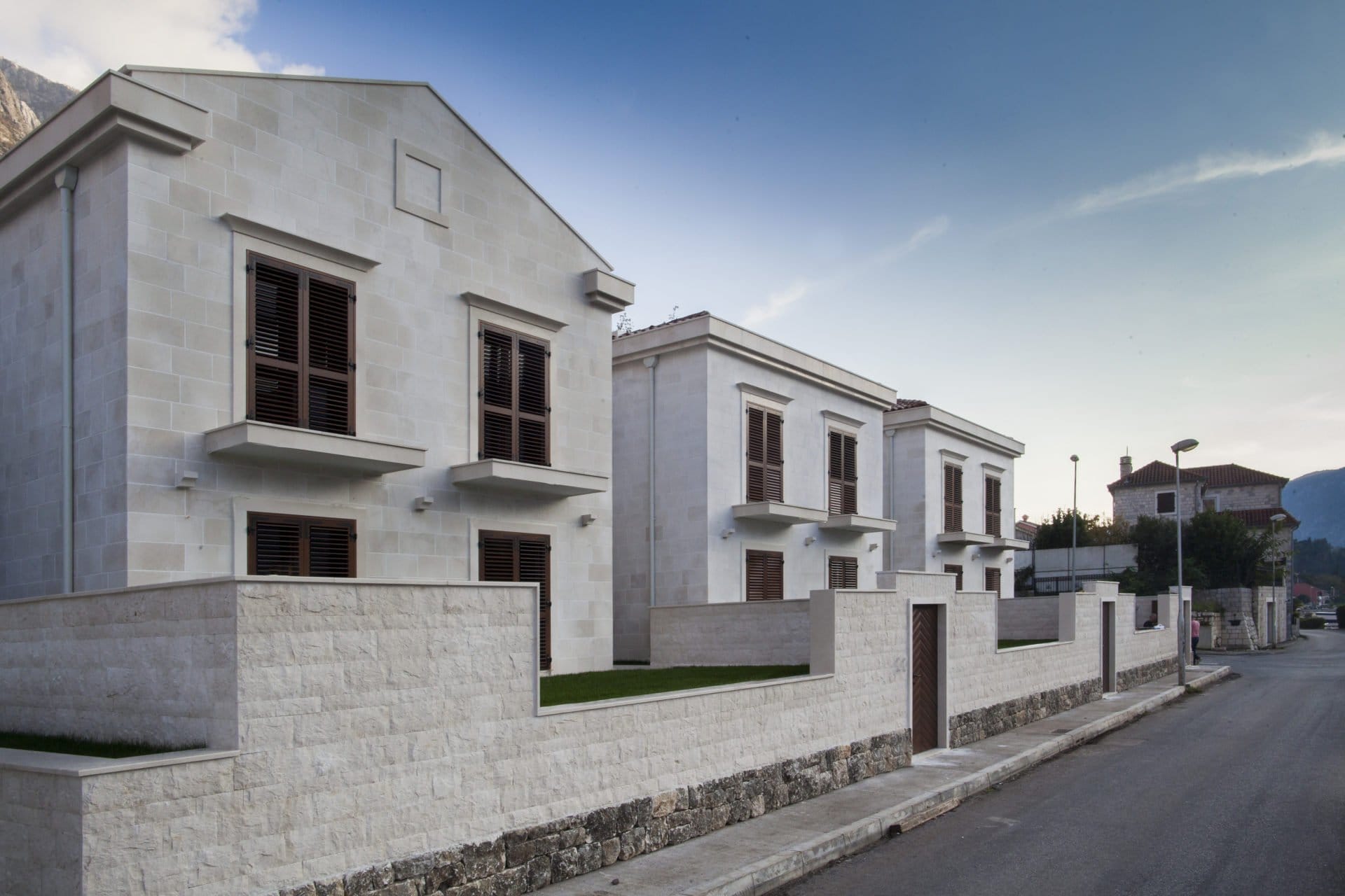 Moderne Steinvillen mit braunen Fensterläden in einer Wohnanlage, Dobrota, Montenegro.