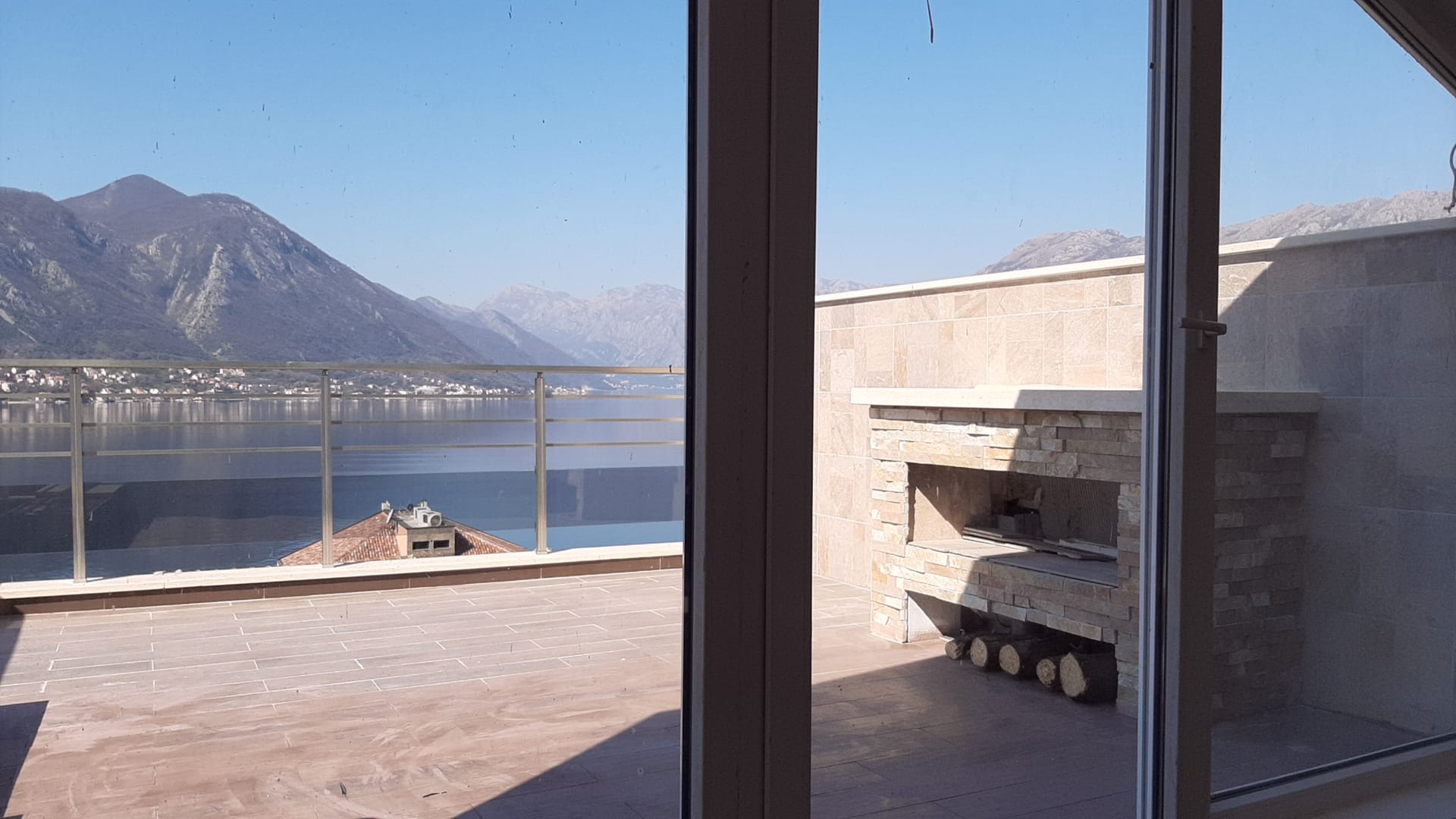 Terrasse mit Steinkamin und Panoramablick auf die Bucht von Kotor und die Berge in Dobrota, Montenegro.